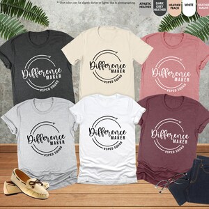 a group of women's t - shirts sitting on top of a wooden floor