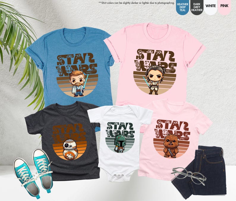May include: A set of four t-shirts featuring Star Wars characters in a retro style. The shirts are in various colors, including blue, pink, white, and grey. Each shirt has a different character, including Obi-Wan Kenobi, Rey, Boba Fett, and R2-D2. The shirts all have the text "Star Wars" in a vintage font.