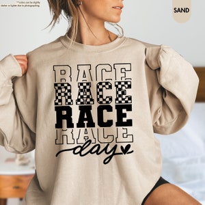 a woman wearing a sweatshirt that says race race race race day