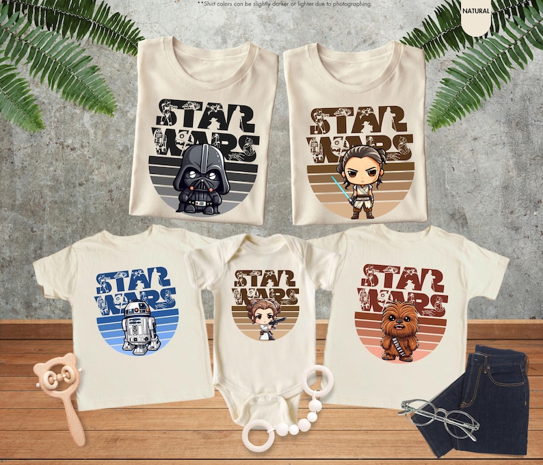 May include: Set of four beige t-shirts with a retro-style Star Wars graphic on each. The shirts feature different characters from the Star Wars franchise, including Darth Vader, Rey, R2-D2, and Chewbacca.