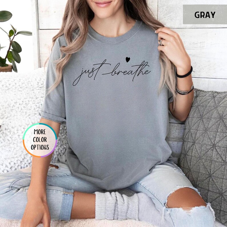 May include: Gray t-shirt with the text "just breathe" and a small heart graphic.