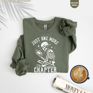 a green shirt with a skeleton on it next to a cup of coffee