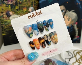 May include: A set of custom press-on nails featuring artwork from a popular animated film. The nails showcase various scenes and characters in a range of colors, including blue, orange, and gold. The set includes a small, blue, decorative nail with a cartoon character.