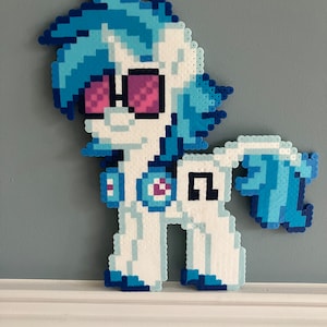 May include: A blue and white pixel art pony with pink glasses and a blue and white symbol on its chest. The pony is standing on a white surface.