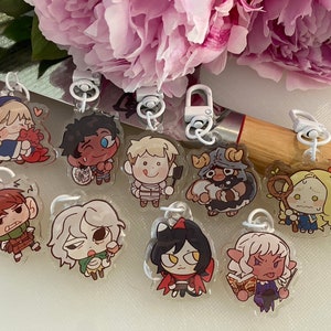 May include: A set of ten clear acrylic keychains featuring cartoon characters. Each keychain has a different character with unique features and expressions. The characters are drawn in a cute and whimsical style.