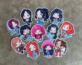 May include: A collection of colorful cartoon stickers featuring various female characters. Each sticker showcases a unique design with different hairstyles, outfits, and accessories. The stickers are arranged on a neutral-toned surface.