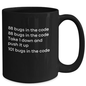 May include: Black coffee mug with white text that reads "88 bugs in the code 88 bugs in the code Take 1 down and push it up 101 bugs in the code".