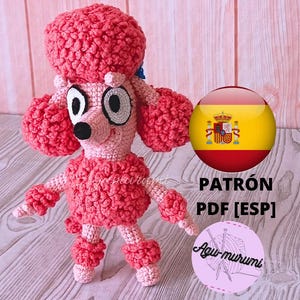 Puede incluir: Un juguete de caniche rosa hecho a mano con ganchillo, con grandes orejas esponjosas y un moño a juego. El caniche tiene ojos grandes y expresivos y una nariz negra. La imagen incluye el texto "PATRÓN PDF [ESP]" y un logotipo.