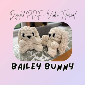 Peut inclure: Deux jouets en forme de lapin en crochet beige avec des yeux et des nez noirs sont présentés. Le texte "Digital PDF + Video Tutorial" et "BAILEY BUNNY" est écrit en script noir. Les lapins sont posés sur une surface à motifs floraux.