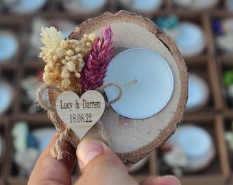 May include: A wooden candle holder with a heart-shaped tag that says "Lucy & Darren 18.08.22" and dried flowers. The holder has a small white tea light candle in the center.