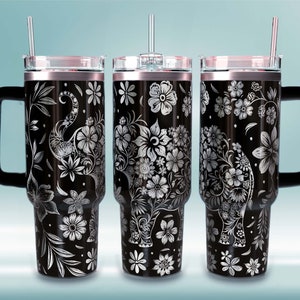 May include: Three black stainless steel travel mugs with a floral design featuring an elephant. Each mug has a black handle and a clear lid with a straw.