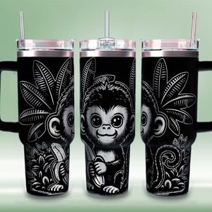 May include: Three black stainless steel travel mugs with a black and white graphic of a monkey holding a banana. Each mug has a black handle and a clear lid with a straw.
