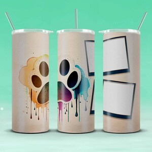 May include: Three stainless steel tumblers with lids and straws. The tumblers have different designs. One has a colorful paw print with drips, one has a colorful paw print with drips and a blue watercolor background, and one has two blank photo frames.