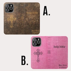 May include: Two phone cases with a religious theme. One is brown with a gold cross and the words "holy bible". The other is pink with a black cross and the words "holy bible". Both have space for initials.