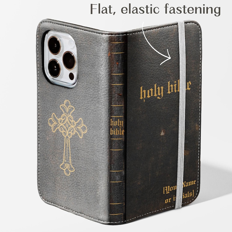 May include: A gray and black leather phone case with a gold cross design and the words "holy bible" in gold lettering. The case has a flat, elastic fastening and a space for initials.
