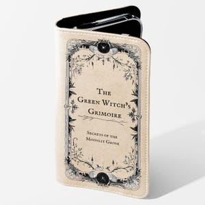 Peut inclure: Une coque de téléphone beige avec une illustration en noir et blanc d'un livre intitulé "The Green Witch's Grimoire: Secrets of the Moonlit Grove".