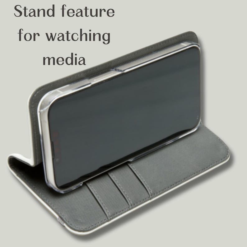 May include: A gray phone case with a stand feature for watching media. The case has a white border and a gray interior with card slots. The phone is in a clear case.