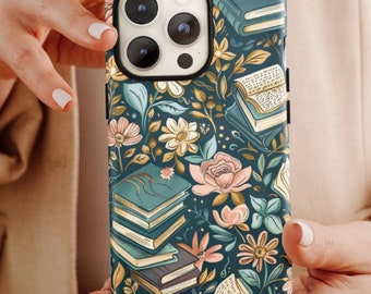 May include: A phone case with a floral and book design. The case has a dark teal background with illustrations of books, flowers, and leaves in shades of pink, yellow, and teal. The phone case is held by a person.