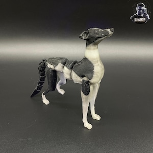 Könnte beinhalten: Eine 3D-gedruckte Skulptur eines Hundes, mit einem schwarz-weißen Farbschema. Der Hund wird in einer stehenden Pose dargestellt, mit schlanker Statur und langem Hals. Der Schwanz ist eingerollt. Die Skulptur befindet sich auf einer dunklen Oberfläche.