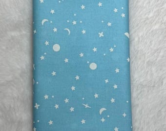 May include: A light blue fabric with a white moon and star pattern. The fabric is perfect for quilting, sewing, and crafting.