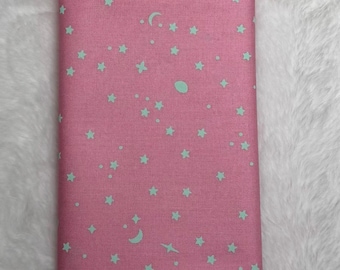 May include: Pink fabric with a white star and moon pattern.