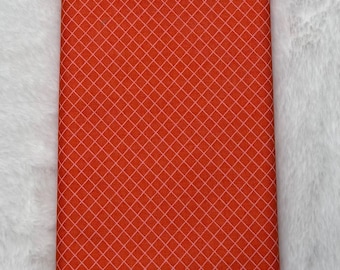 May include: Orange fabric with a white diamond pattern.