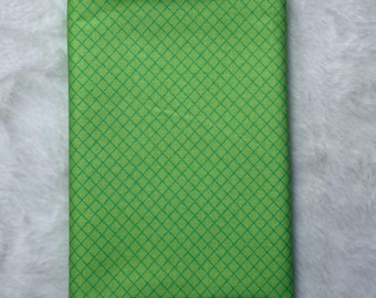 May include: A green fabric with a diamond pattern. The fabric is a light green color with a darker green diamond pattern.