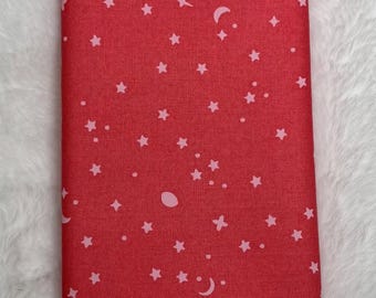 May include: Red fabric with a white background featuring a repeating pattern of pink stars, moons, and other celestial shapes.