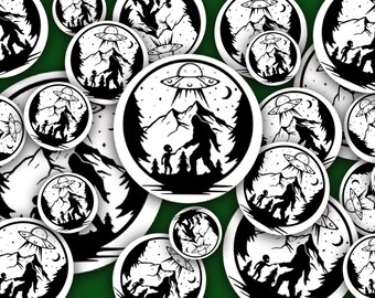 May include: A collection of black and white stickers featuring a Bigfoot character with a UFO in the background. The stickers are circular and have a white background with black outlines.