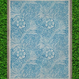 Blue William Morris Woven Blanket on top of  Bright Green Grass