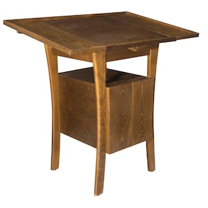 Puede incluir: Una mesa de madera marrón oscuro con una tapa elevable y un armario con una sola puerta. La mesa tiene patas curvas y una tapa rectangular.