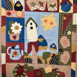 May include: A patchwork quilt with a variety of colors and patterns, including red, blue, green, and brown. The quilt features a variety of images, including birds, flowers, a sun, and a watering can. The quilt is made of fabric scraps and has a rustic, handmade look.