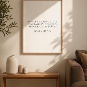 Puede incluir: Una impresión enmarcada con el texto "PERO EN CUANTO A MÍ Y A MI FAMILIA, NOSOTROS SERVIREMOS AL SEÑOR. JOSUE 24:15 NTV." se muestra en una pared. Debajo hay un banco de madera con tres jarrones de cerámica.