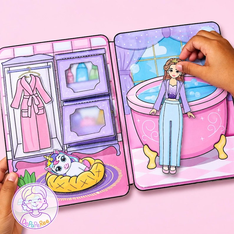 May include: A paper doll playset featuring a bathroom and closet scene. The set includes a paper doll character, a pink bathtub, a purple wardrobe with a pink robe, and a small unicorn in a yellow bed. The scene is illustrated in pastel colors.