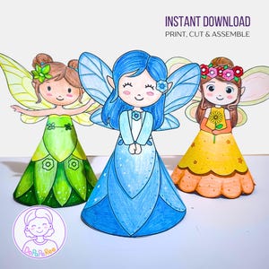 Könnte beinhalten: Drei farbenfrohe Papierfeenpuppen mit Flügeln, jede mit einem einzigartigen Kleid und Frisur. Die Feen sind in Grün-, Blau- und Gelbtönen gehalten. Der Text "INSTANT DOWNLOAD PRINT, CUT & ASSEMBLE" ist oben zu sehen.