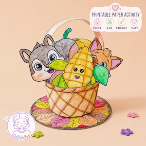 Puede incluir: Una cesta de papel con una mazorca de maíz, una ardilla y un zorro de dibujos animados, coloreados con rotuladores. La cesta se asienta sobre una base circular decorada con hojas de otoño. El texto superior dice PRINTABLE PAPER ACTIVITY PRINT CUT CREATE PLAY.