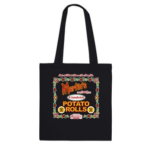 Può includere: Borsa tote in tela nera con un design grafico rosso e giallo con il testo "Martin's Dutch Oven 8 Sandwich Potato Rolls".