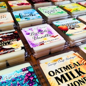 May include: A collection of rectangular wax melts in clear plastic containers, each featuring a label with the Savage Craft Boutique logo and specific scent names like Lavender Vanilla, Sandalwood Vanilla, Oatmeal, Milk, Honey, and Coconut Bliss.