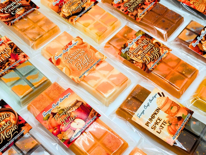 May include: A collection of rectangular soy wax melt bars in clear plastic packaging, each featuring a label with scent names like Pumpkin Crunch Cake, Vanilla Pumpkin Fluff, Pumpkin Caramel Drizzle, Pumpkin Apple Butter, and Pumpkin Spice Latte.
