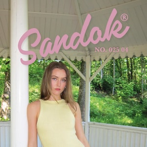 Könnte beinhalten: Ein hellgelbes Minikleid mit schwarzem Gürtel. Das ärmellose Kleid hat Rippen. Das Bild enthält den Text "Sandak" in rosa Schrift, sowie "NO. 025 04" und "MINI DRESS 2 SIZE XS-XXL". Der Hintergrund ist ein weißer Pavillon.