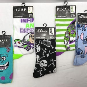 Può includere: Cinque paia di calzini da equipaggio con personaggi Disney e Pixar. I disegni includono Sully di Monsters, Inc., Buzz Lightyear, Jack Skellington, Stitch e un design a righe di Buzz Lightyear. Ogni paio è taglia 9-13.
