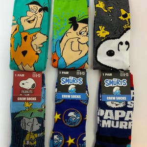 以下が含まれることがあります： 漫画のキャラクターが描かれたクルーソックス6足セット。 フリントストーン、スヌーピー、スマーフのデザインが含まれています。 各ペアは、ティール、グリーン、グレー、ブルー、ネイビーなど、異なる配色です。 ソックスのサイズは6〜13です。