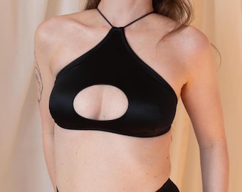 Top deportivo negro con aberturas, ideal para fiestas rave y pole dance.