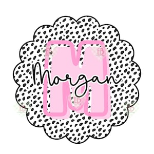 Puede incluir: Un círculo de lunares negros y blancos con una letra M rosa en el centro. La palabra "Morgan" está escrita en cursiva negra debajo de la letra.