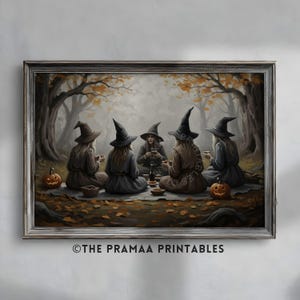 May include: A framed print depicts five witches in black hats and dresses gathered in a forest. They are seated around a picnic blanket, enjoying a meal. Two carved pumpkins sit nearby. The artwork has a muted color palette with autumn leaves and trees.
