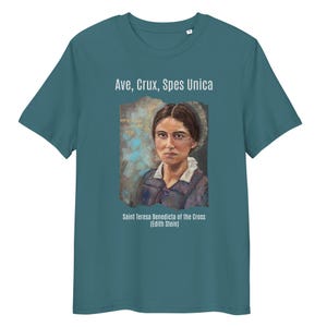 Puede incluir: Camiseta de color verde azulado con un retrato de Santa Teresa Benedicta de la Cruz (Edith Stein). La frase latina "Ave, Crux, Spes Unica" está impresa encima del retrato. El retrato es de estilo pintado.