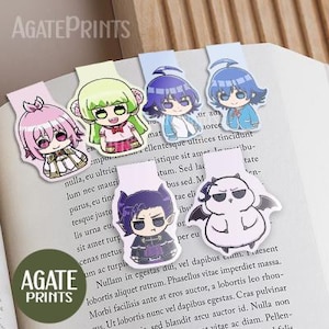 May include: A selection of anime-style character bookmarks in various colours. Each bookmark displays a distinct character design with bright colours and detailed artwork. The bookmarks are on an open book. The text "AGATEPRINTS" is visible.