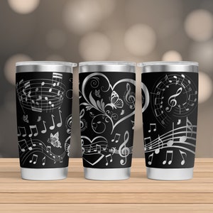 May include: Three stainless steel tumblers with black and silver musical note designs. The tumblers feature a heart with a treble clef and a butterfly design, musical notes, and a treble clef.