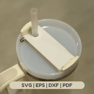 May include: White travel mug with a lid and a straw holder. The lid has a white plastic insert with a hole for a straw. The mug has a handle and a white plastic ring around the bottom. The text "SVG | EPS | DXF | PDF" is printed on the bottom of the mug.