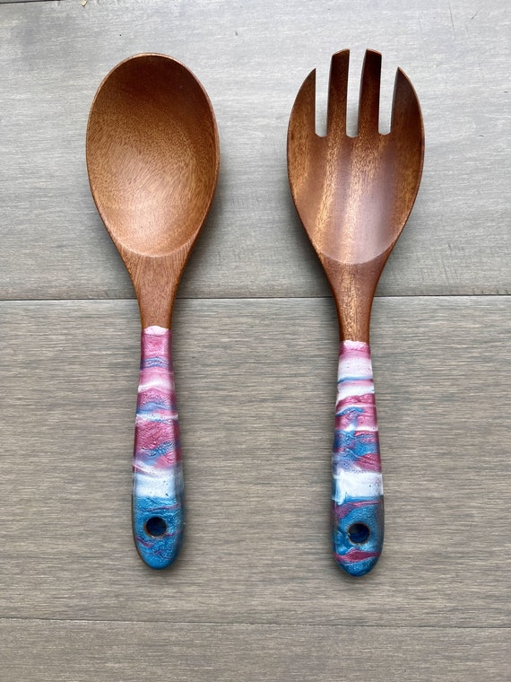 Resin-swirled wood serving spoons where every set is a one-of-a-kind wearable painting — functional craft at its best.